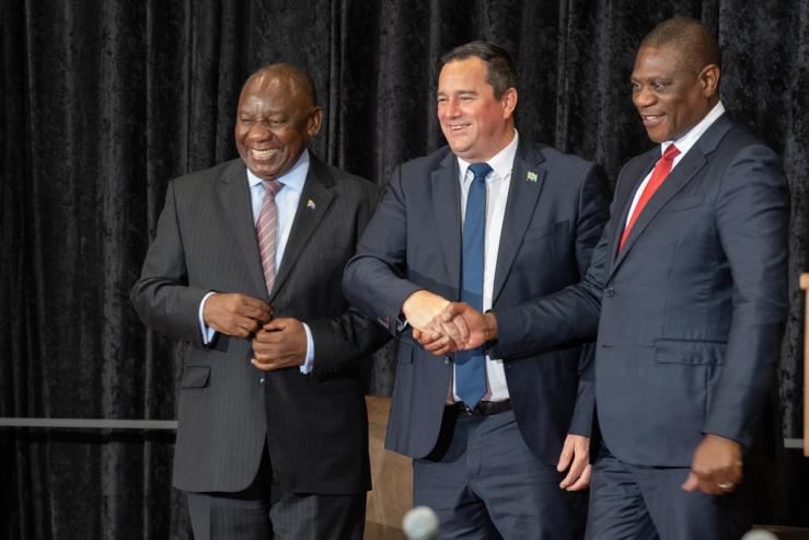 South African President Cyril Ramaphosa (L) smiles as leader of the Democratic Alliance Party John Steenhuisen (C) shakes hands with South African Deputy President Paul Mashatile (R)