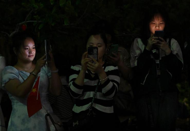 People looking at their smartphone in China.