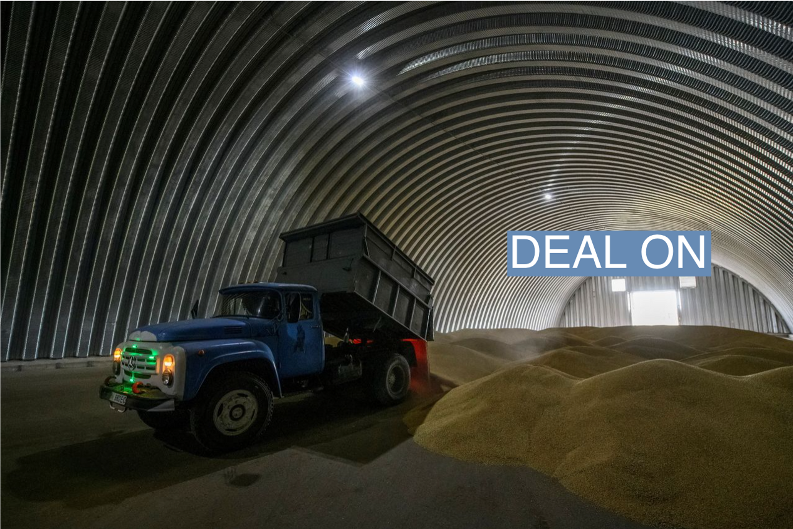 An employee unloads wheat grains inside a storage in the village of Zghurivka, amid Russia's attack on Ukraine, in Kyiv region, Ukraine