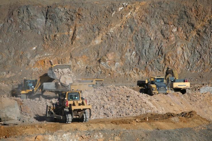 Wheel loaders fill trucks with ore at rare earth mine