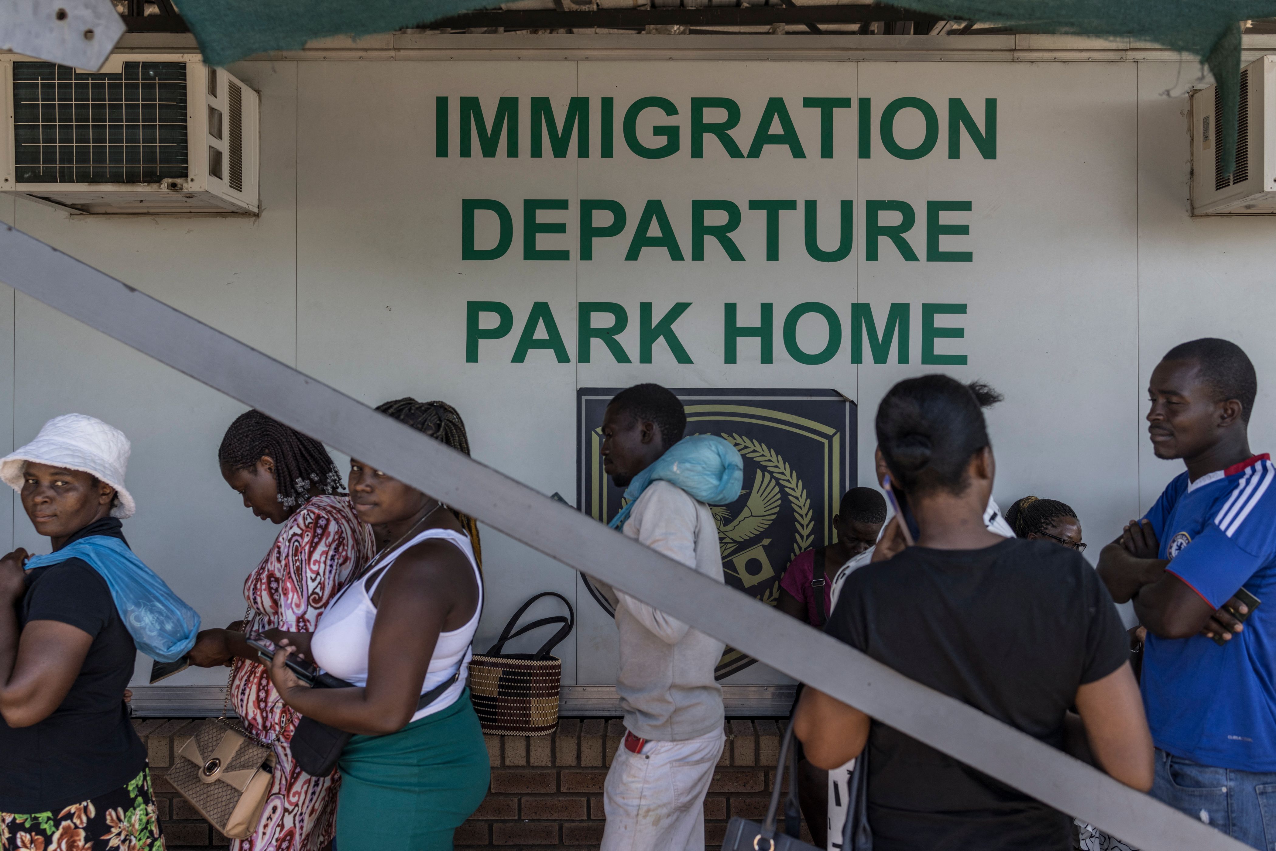 Zimbabwean migrants wishing to enter South Africa queue at a passport check.