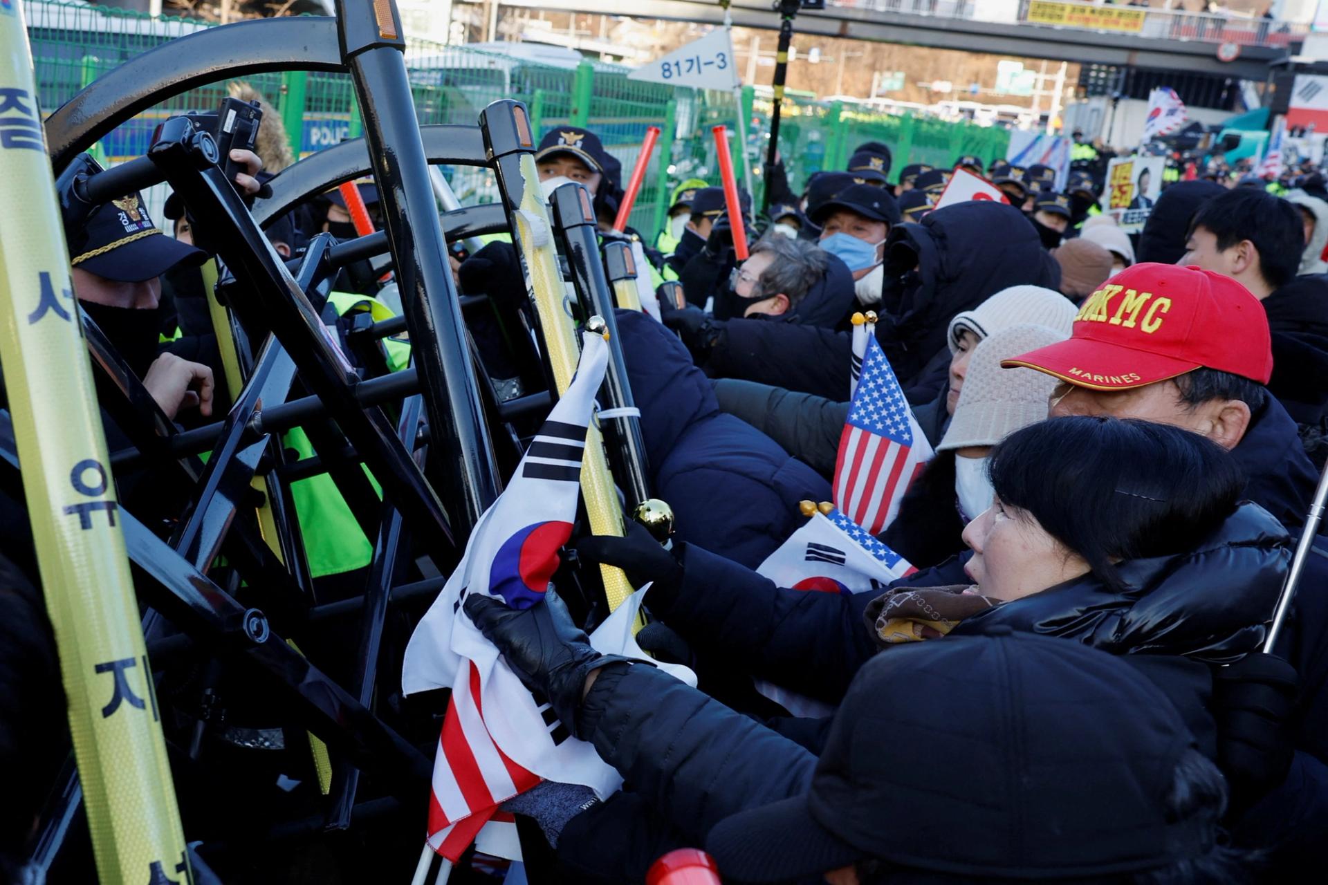 Yoon’s supporters scuffle with police officers as they seek to execute an arrest warrant.