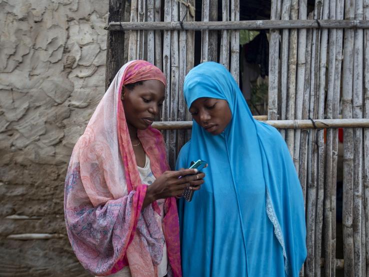 Women on their phones in Mozambique.