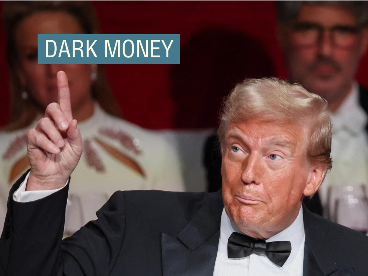 Donald Trump, wearing a black tuxedo, points to the ceiling at the 79th annual Alfred E. Smith Memorial Foundation Dinner in New York City