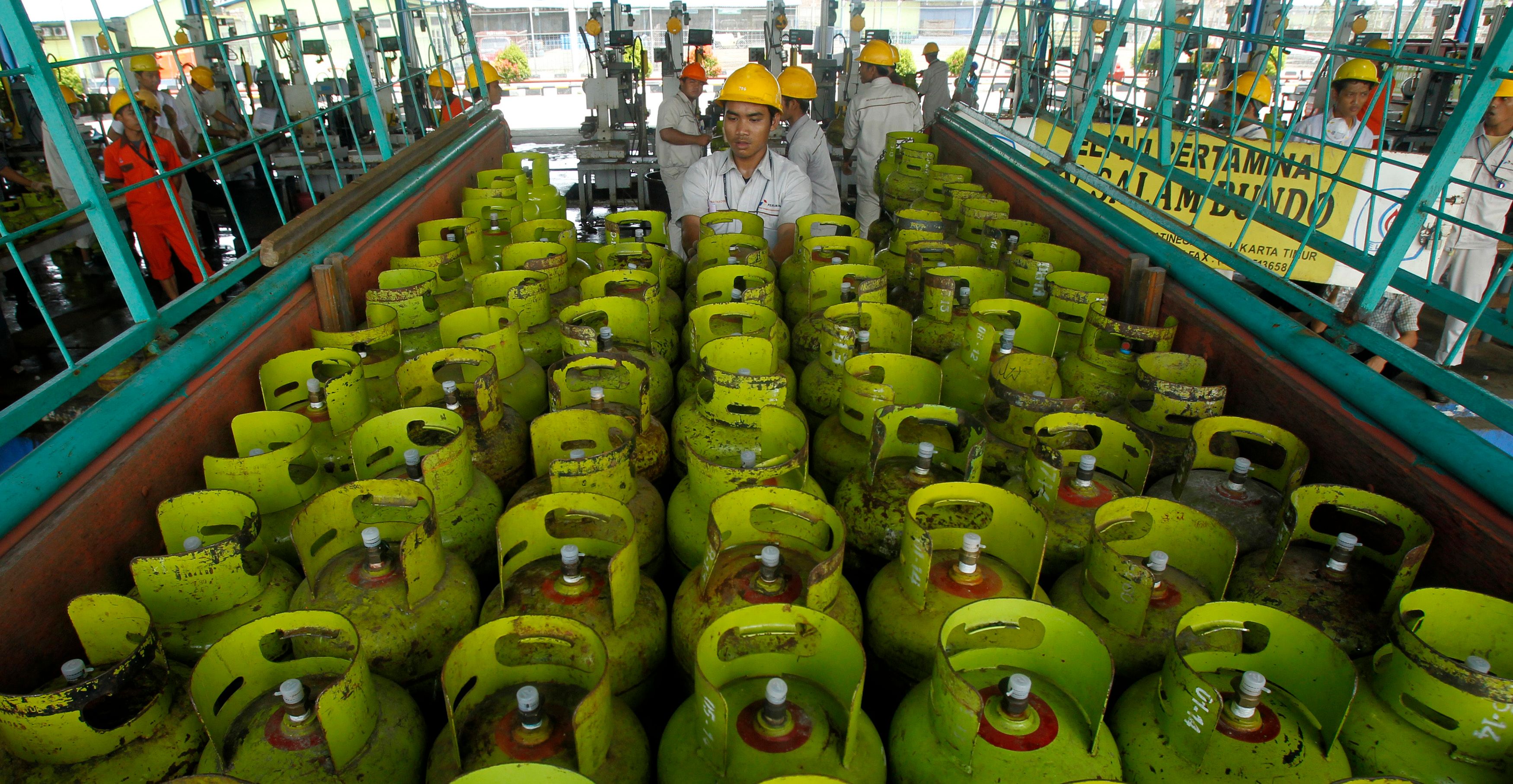 Workers upload LPG (liquid petroleum gas) canisters before sending to customers in PT Pertamina LPG filling station in Jakarta