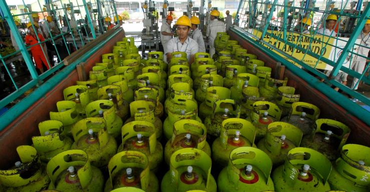 Workers upload LPG (liquid petroleum gas) canisters before sending to customers in PT Pertamina LPG filling station in Jakarta