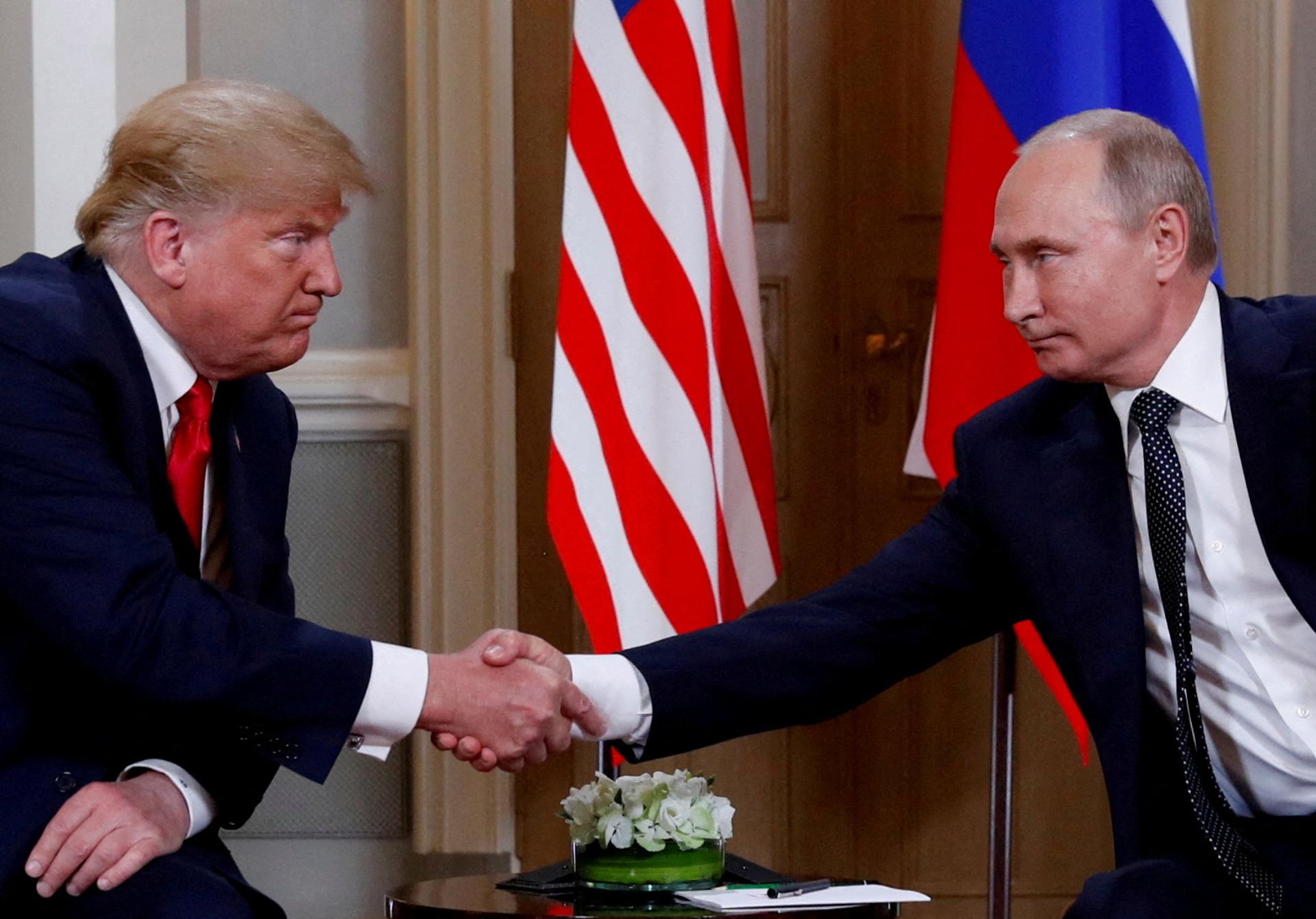 U.S. President Donald Trump and Russian President Vladimir Putin shake hands in 2018. 