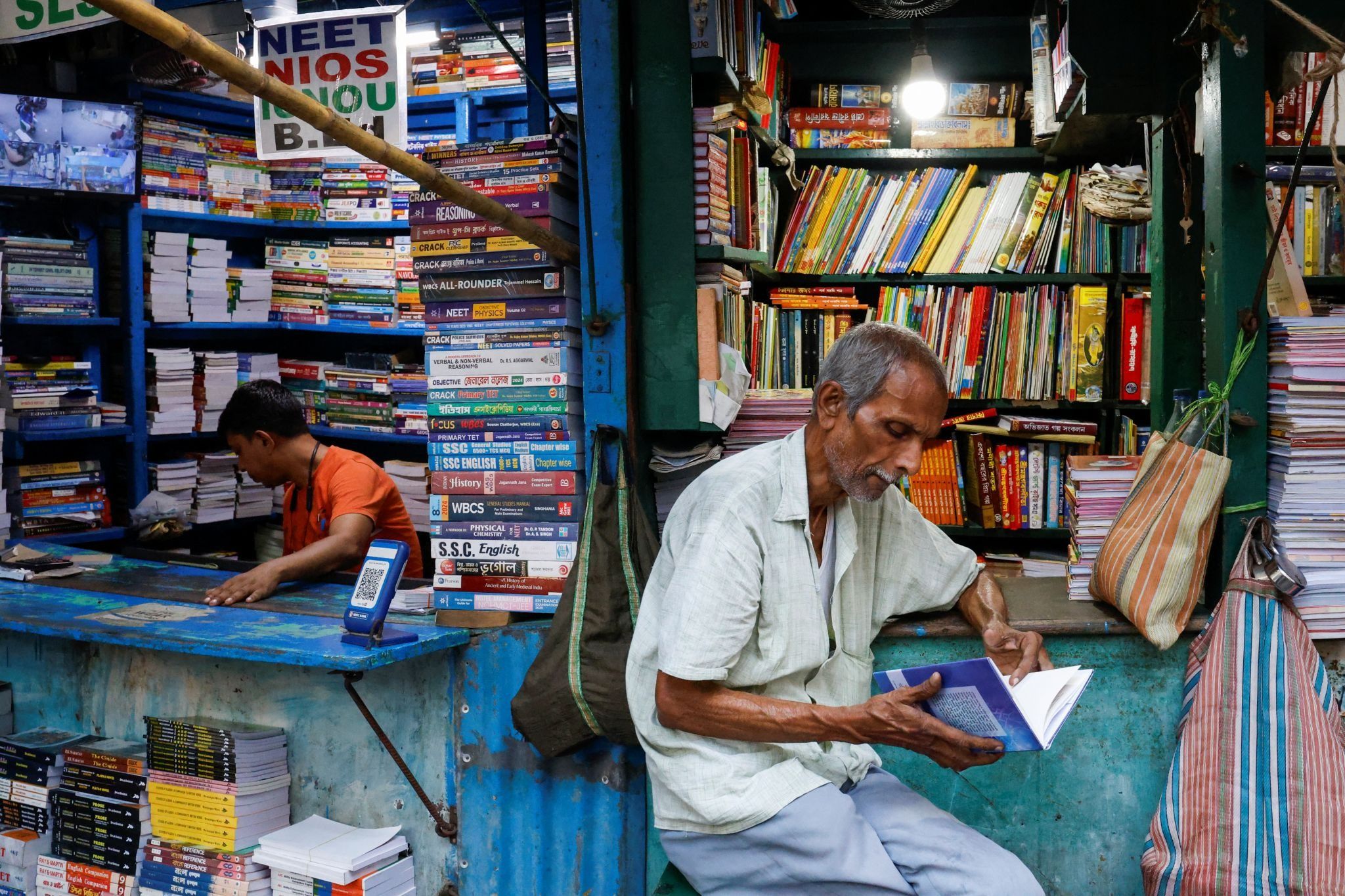  A shopkeeper reads a book in Kolkata. 