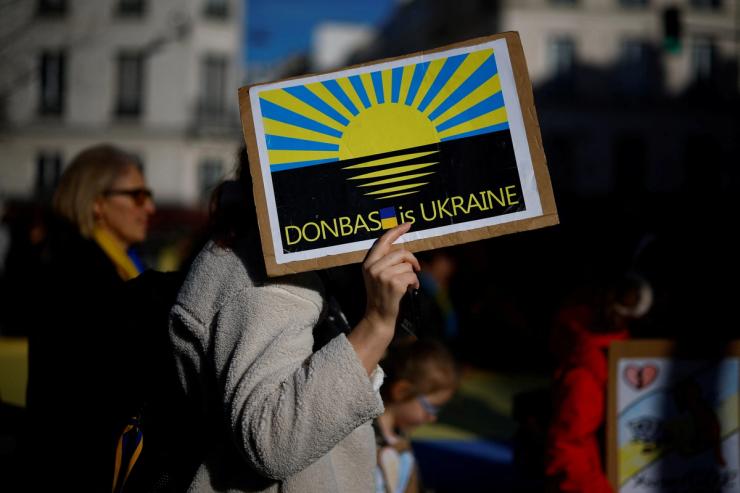 A woman holds a placard during a protest in Paris.