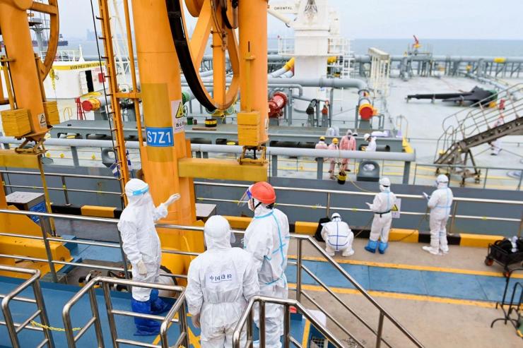 Immigration inspection officers check a tanker carrying imported crude oil at the port in Qingdao