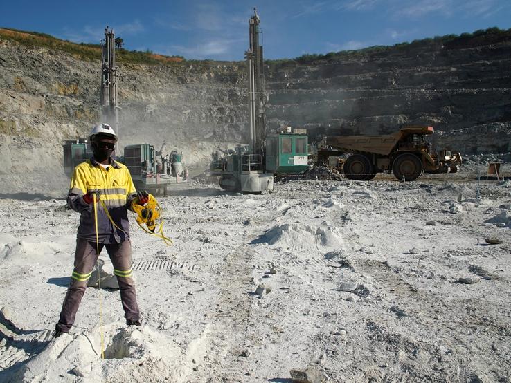 A miner measures the depth of blast holes at the Kibali gold mine Haut-Uele province, Democratic Republic of Congo.