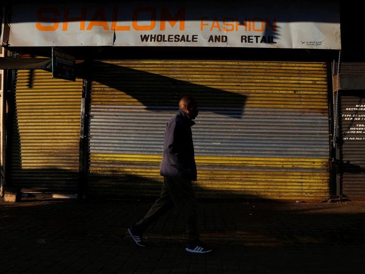 A man walks by a closed shop in Johannesburg.