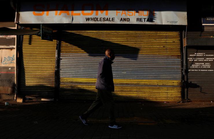 A man walks by a closed shop in Johannesburg.