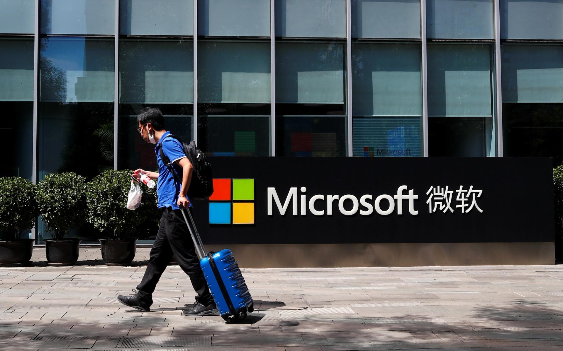 A person walks past a Microsoft logo at the Microsoft office in Beijing, China, 2020.