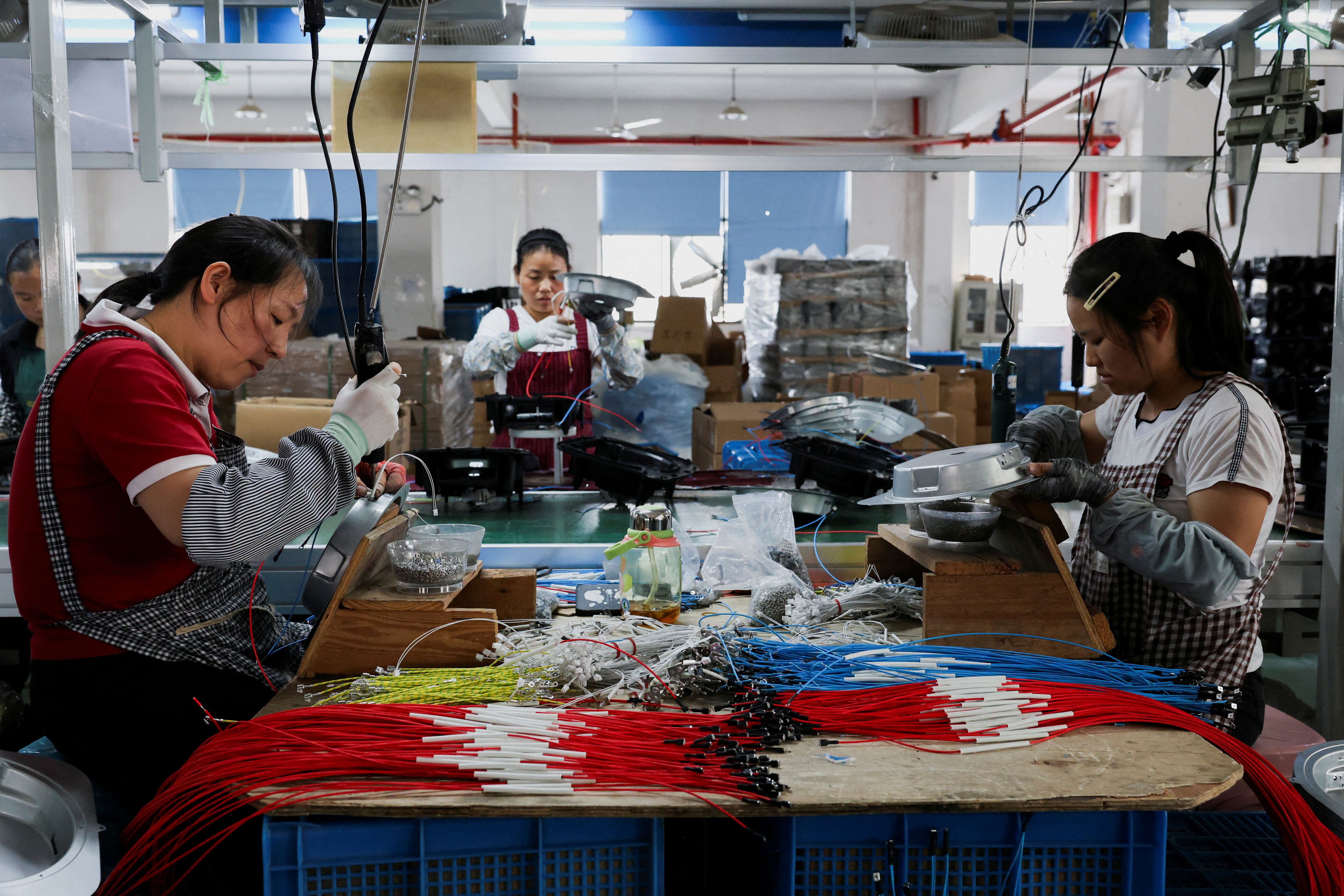 Employees of Gstar Electronic Appliance Co., Ltd work to assemble air fryers.