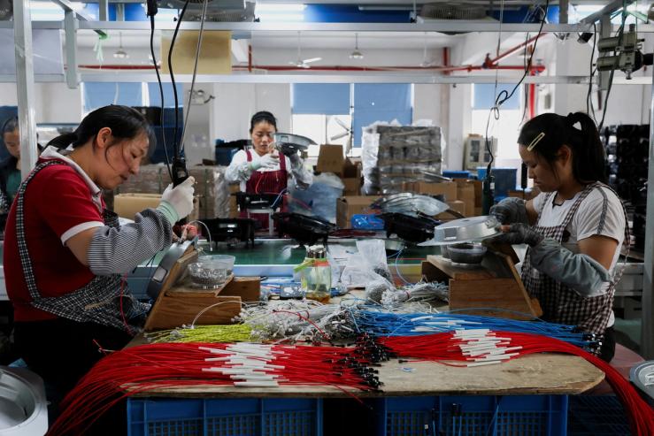 Employees of Gstar Electronic Appliance Co., Ltd work to assemble air fryers.