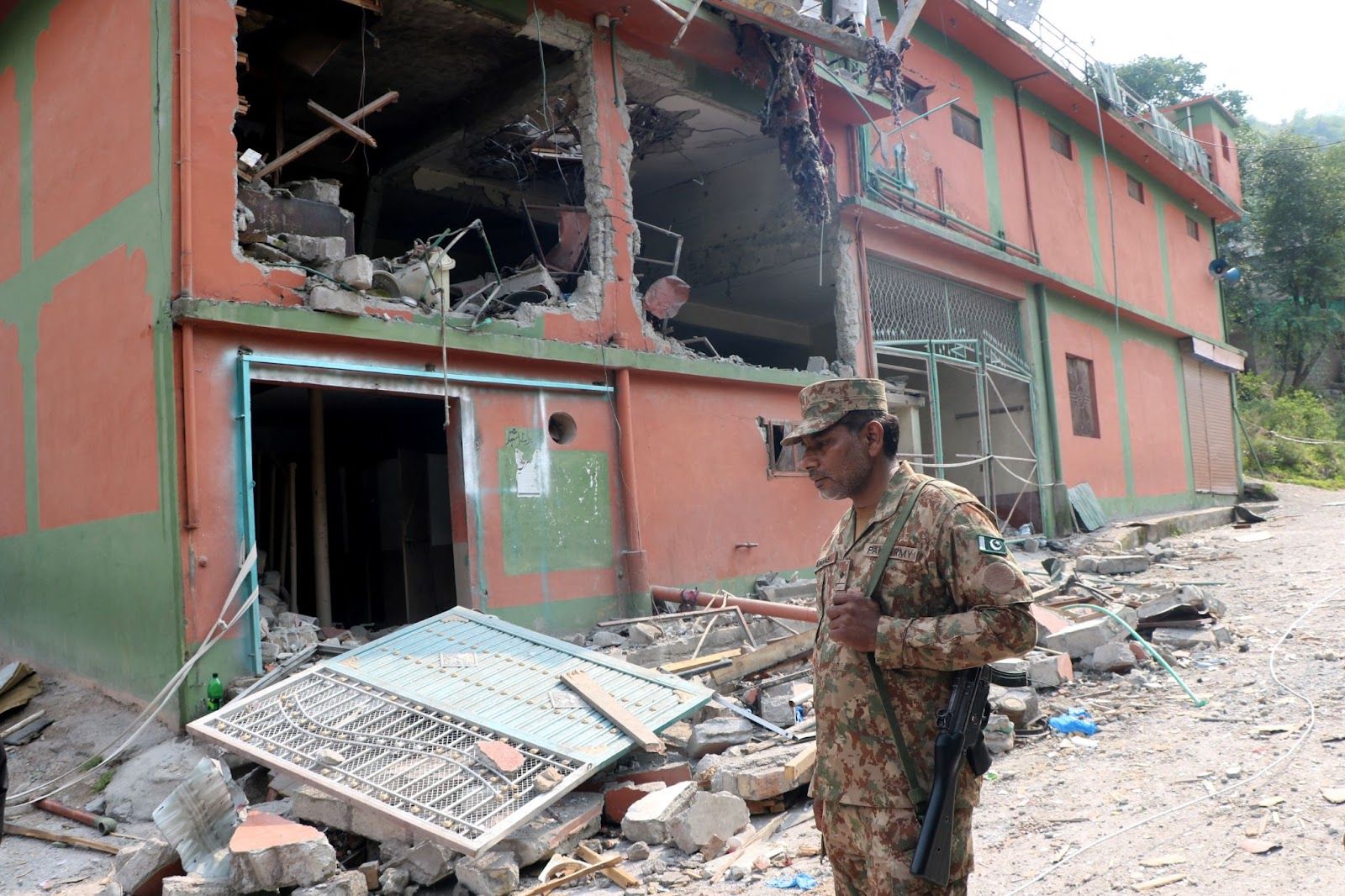 A Pakistan Army soldier stands in front of damaged Bilal Mosque after it was hit by an Indian strike in Muzaffarabad.