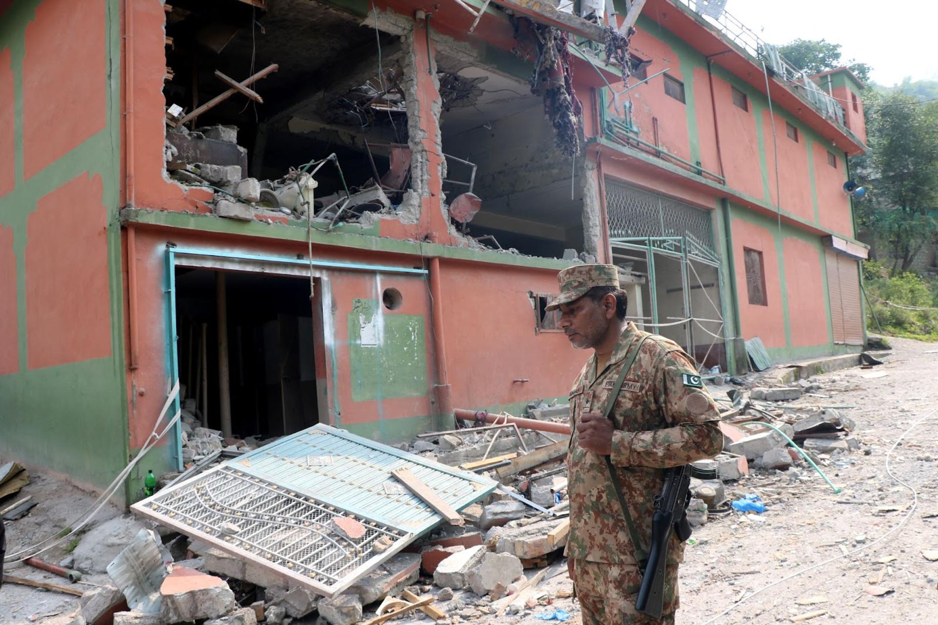 A Pakistan Army soldier stands in front of damaged Bilal Mosque after it was hit by an Indian strike in Muzaffarabad.