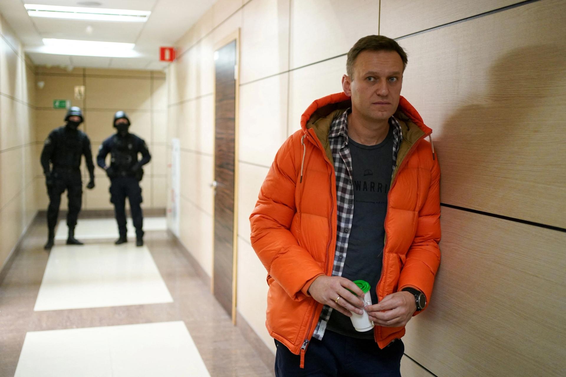 Russian opposition leader Alexei Navalny stands near law enforcement agents in a hallway of a business center that houses the office of his Anti-Corruption Foundation (FBK), in Moscow on Dec. 26, 2019.
