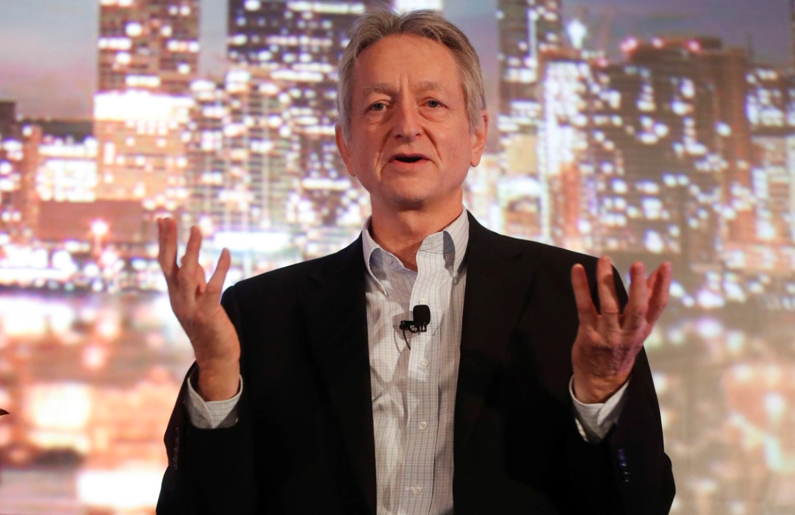 A photo of Geoffrey Hinton holding his hands up