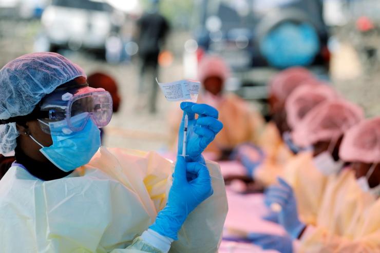 A health worker fills a syringe with the vaccine for a different strain of Ebola in 2019.