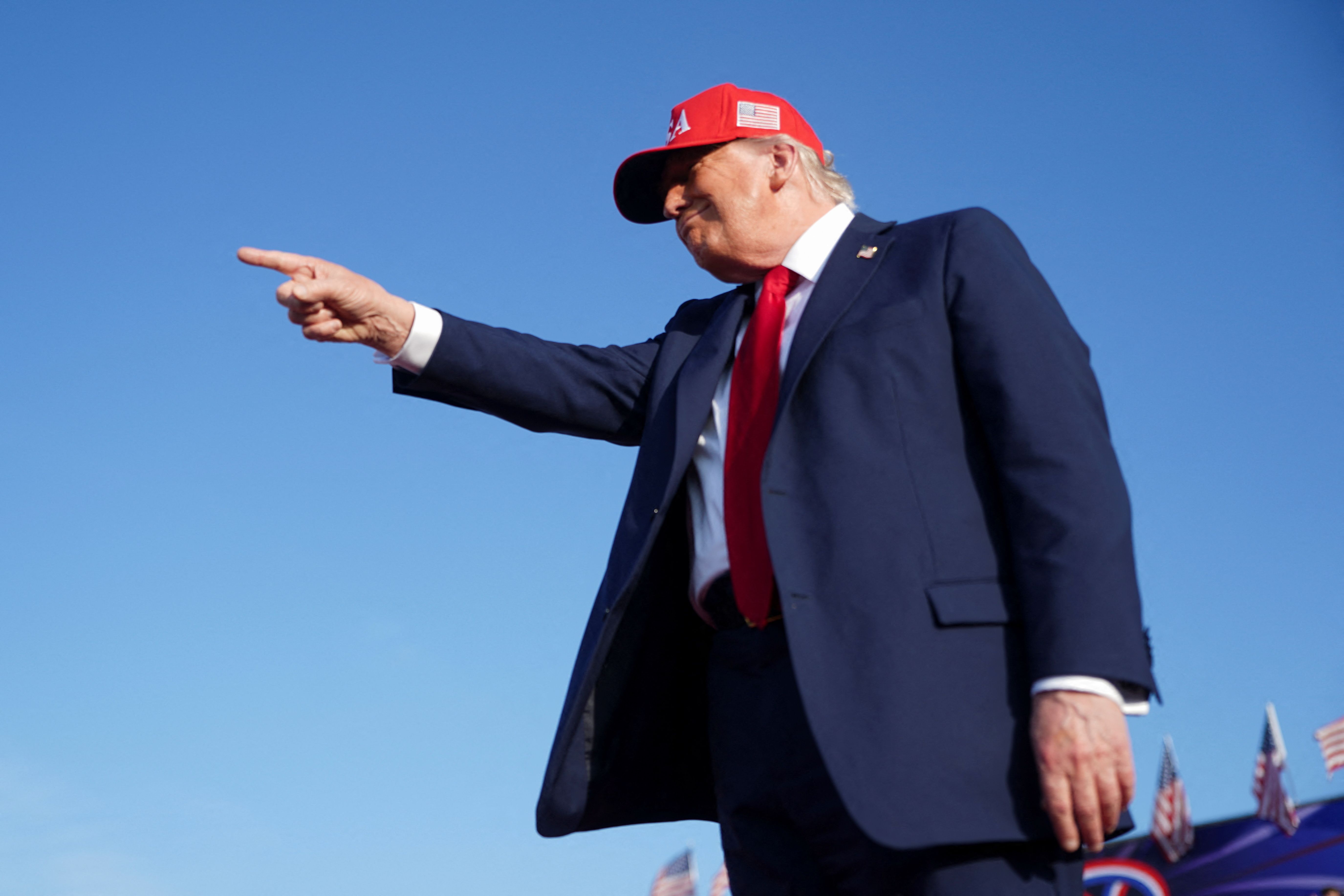 US President Donald Trump points at a rally.