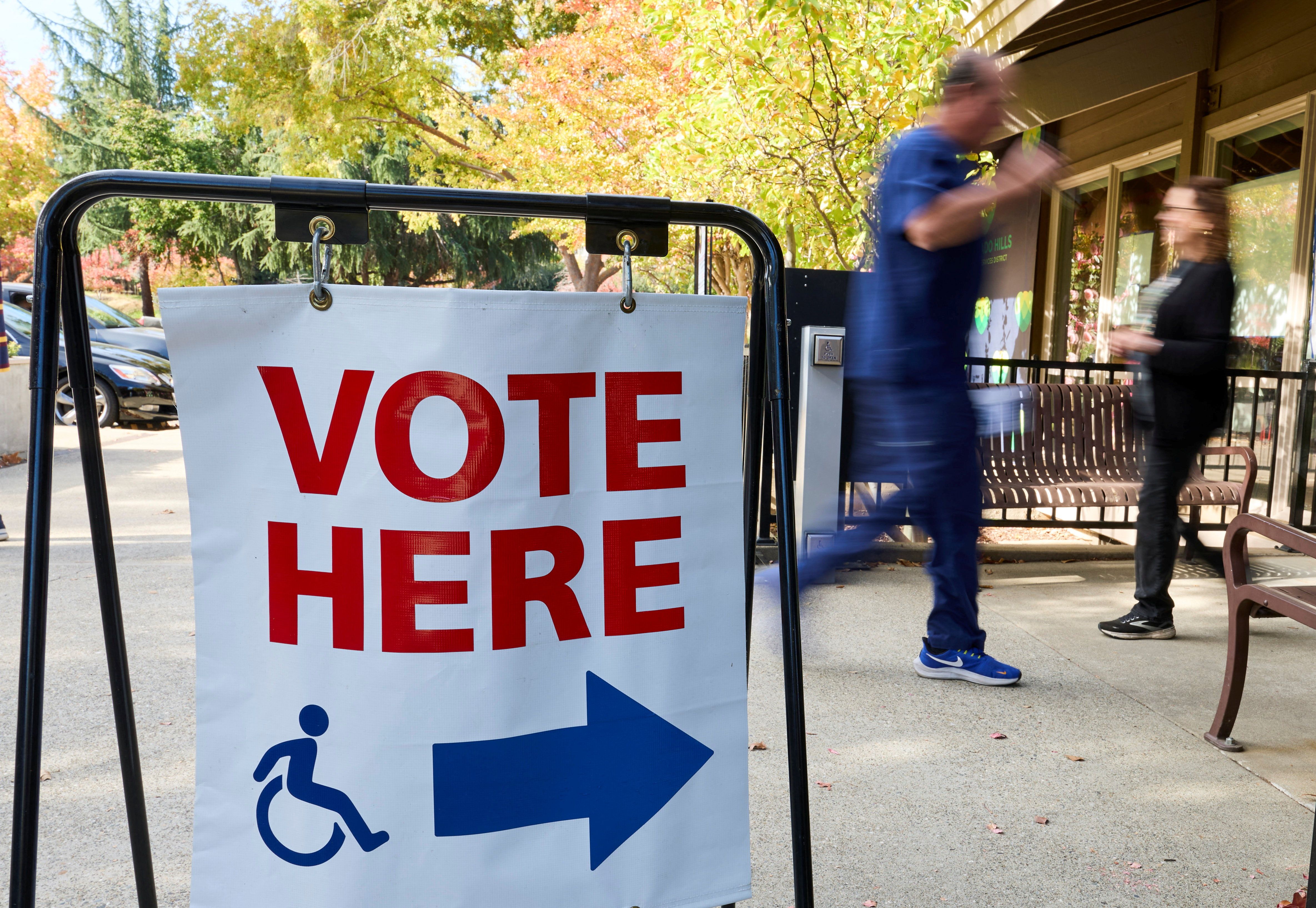 Voters walk past a “vote here” sign at an El Dorado County polling station during California’s special election.