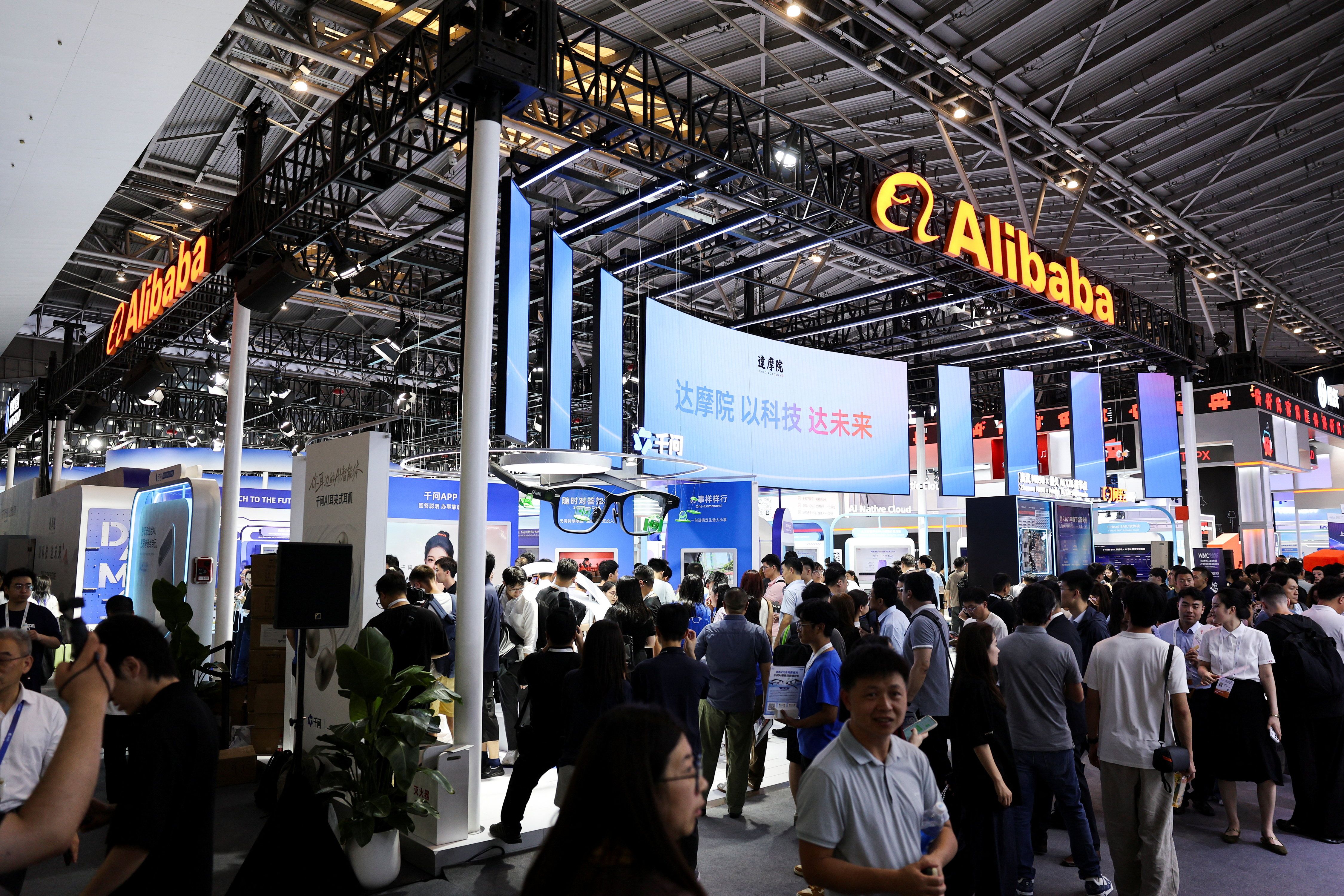 People walk past the Alibaba booth during the World Artificial Intelligence Conference. 