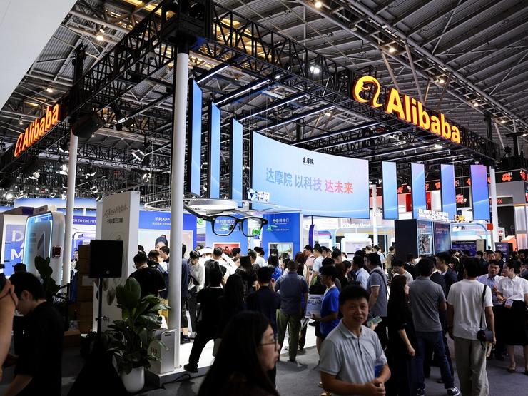 People walk past the Alibaba booth during the World Artificial Intelligence Conference.