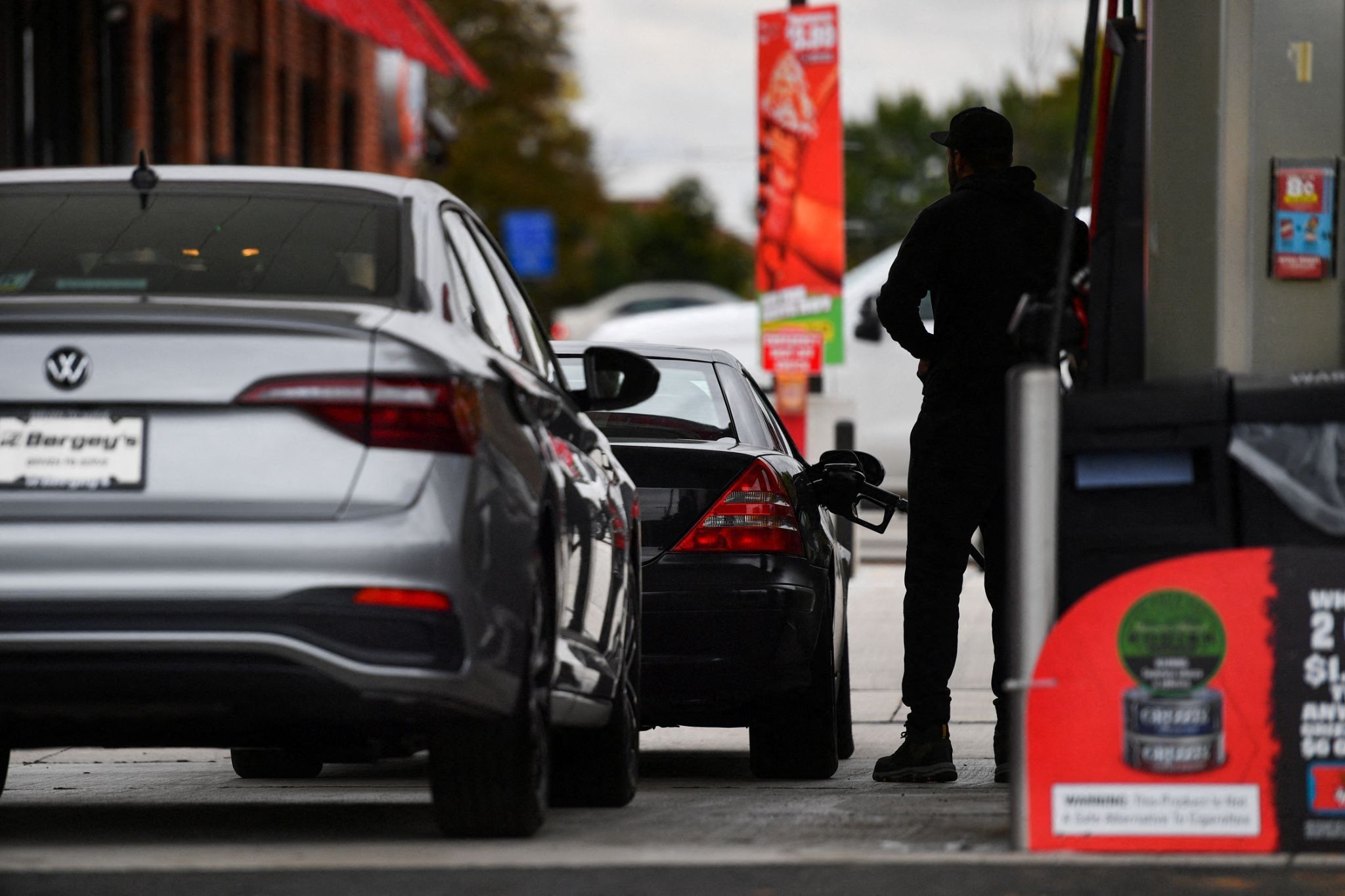 A man fills up his car with gasoline.
