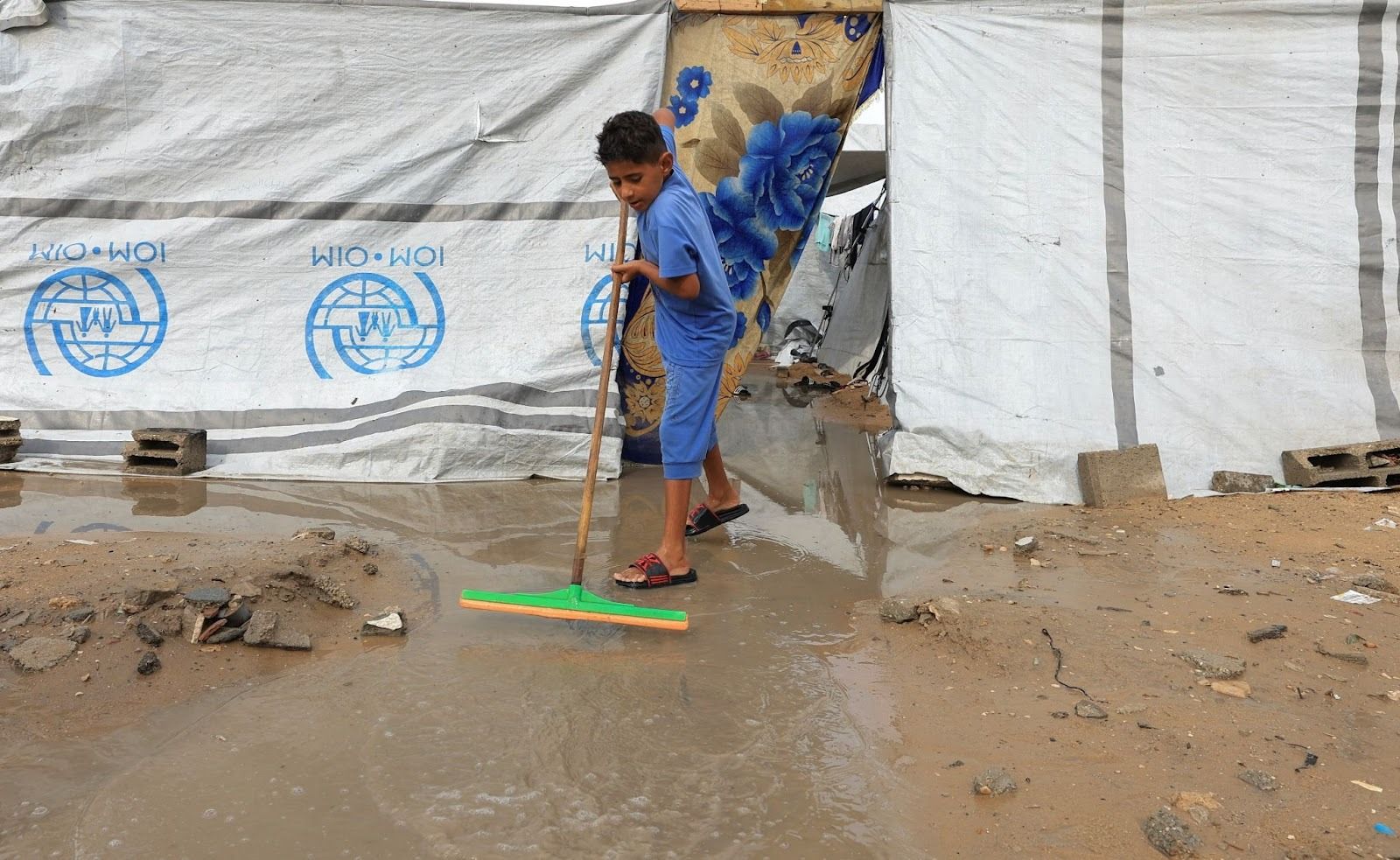 A boy clearing water in Gaza. 