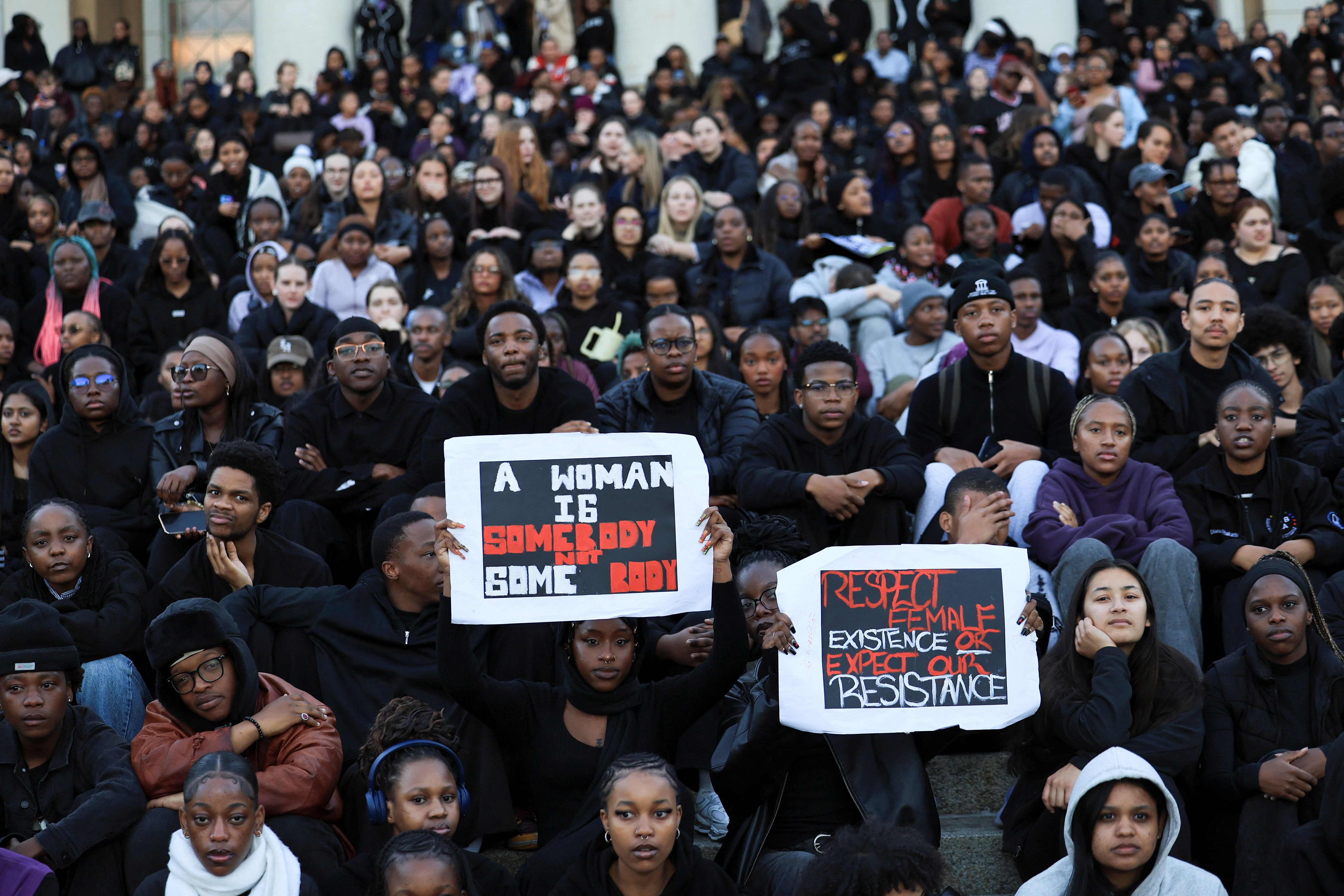 Students hold placards at the University of Cape Town during a vigil for victims of gender-based violence and femicide.