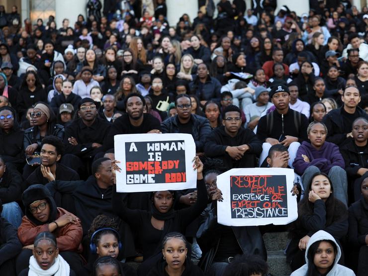Students hold placards at the University of Cape Town during a vigil for victims of gender-based violence and femicide.