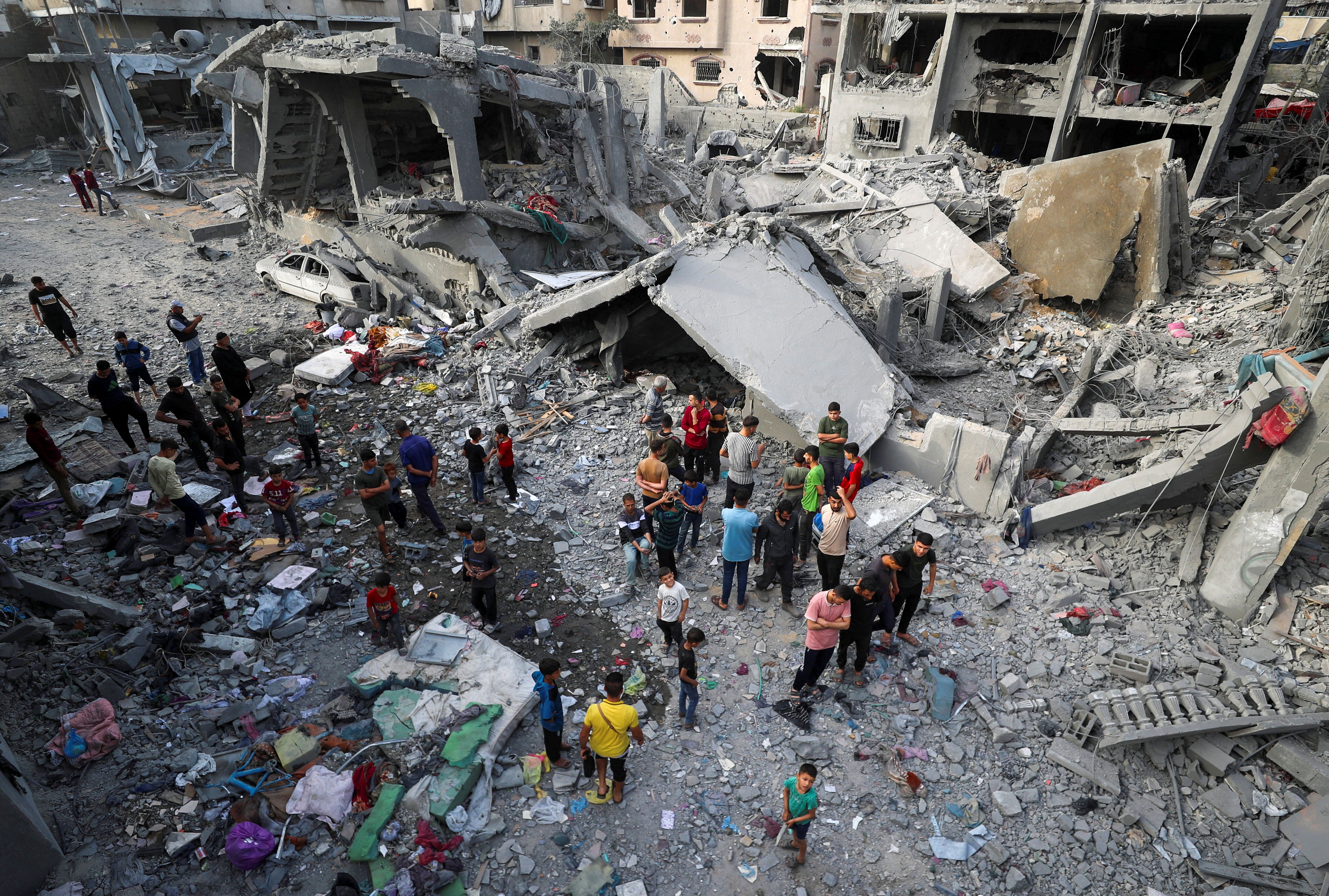 Palestinians inspect the site of an Israeli strike on a house in Gaza.