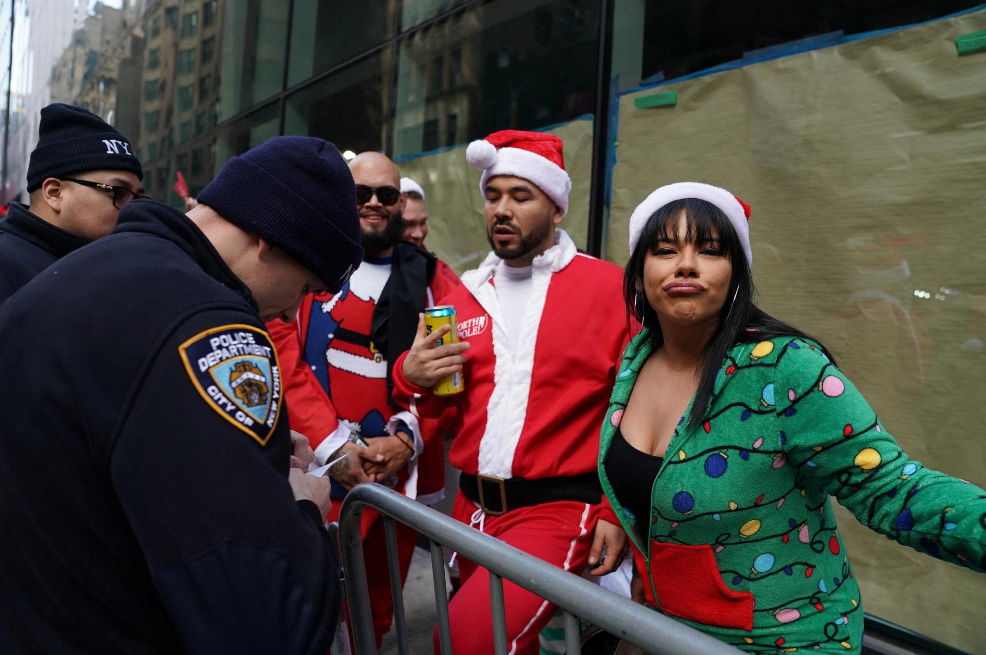 A police officer writes a ticket for a reveller at the SantaCon in New York City, New York, U.S., December 9, 2023.