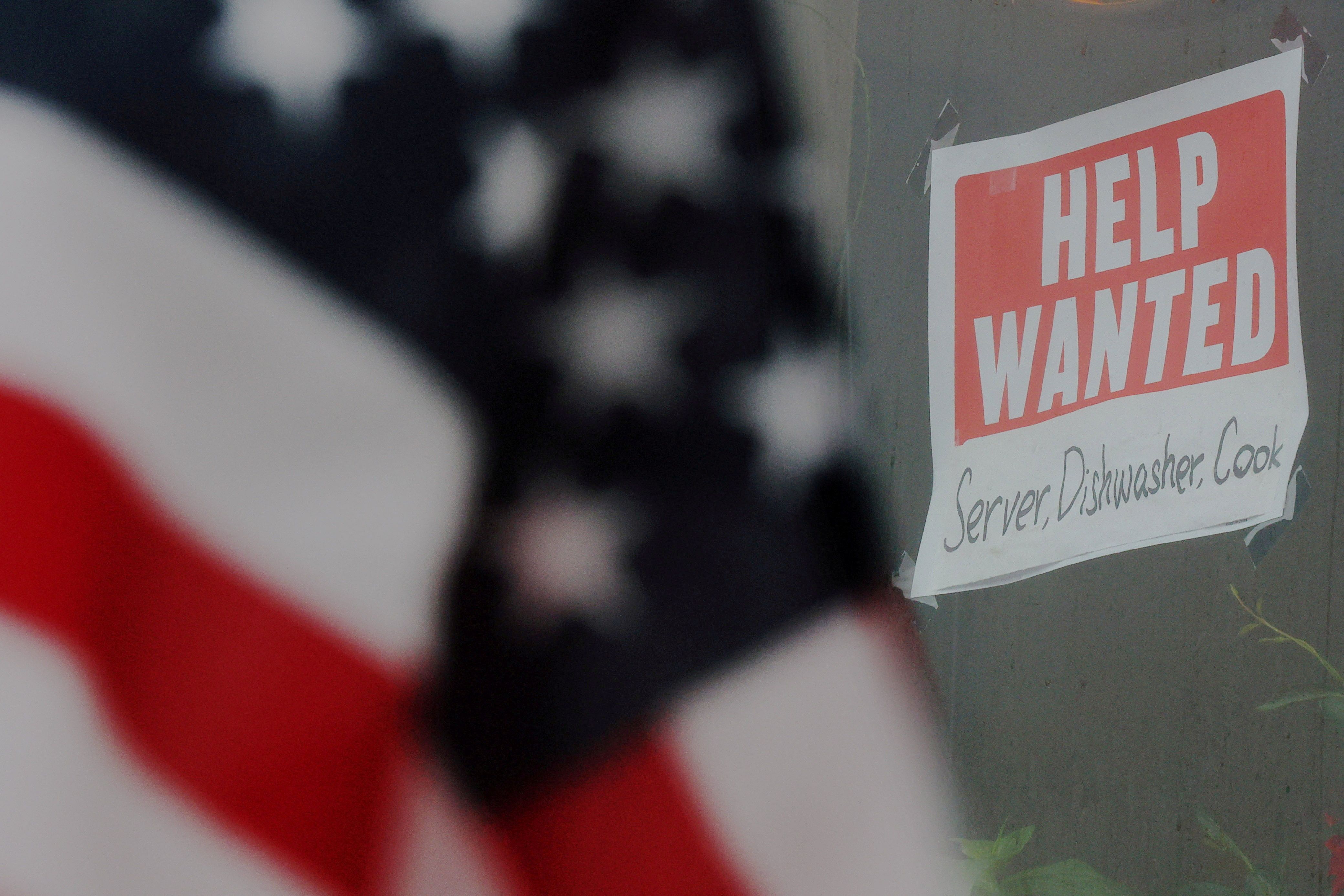 A Help wanted sign and an American flag