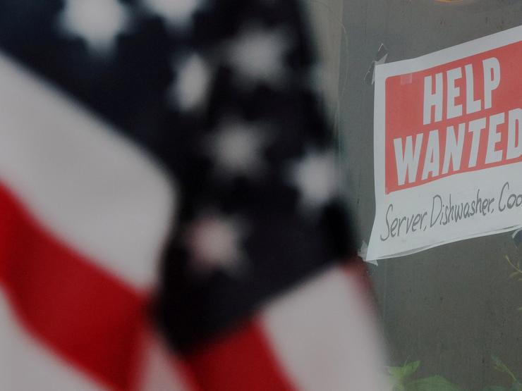 A Help wanted sign and an American flag