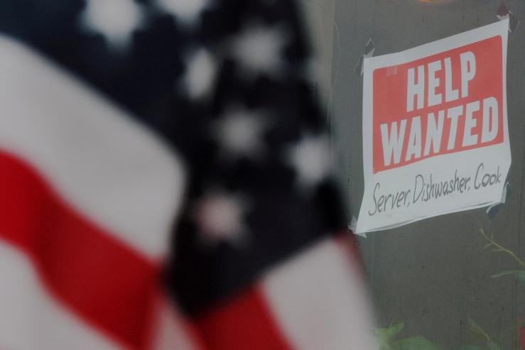 A Help wanted sign and an American flag