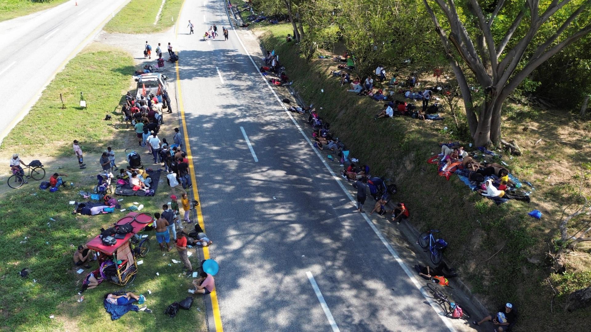 Migrants resting on the side of a road as part of caravan bound to the northern border with the US