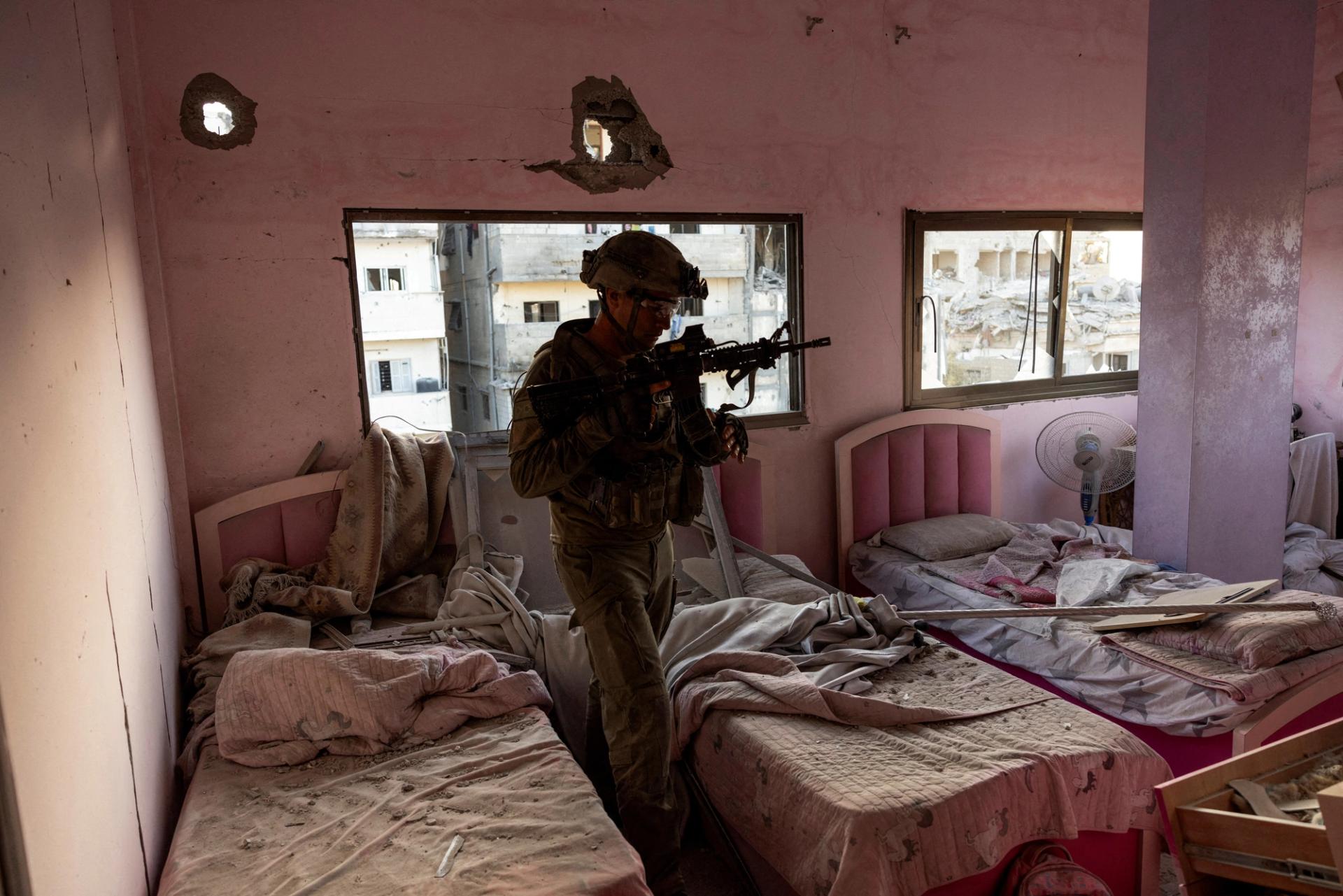 An Israeli colonel walks through a damaged bedroom inside a residential building amid the ongoing operation against Palestinian Islamist group Hamas in the northern Gaza Strip, November 8, 2023.