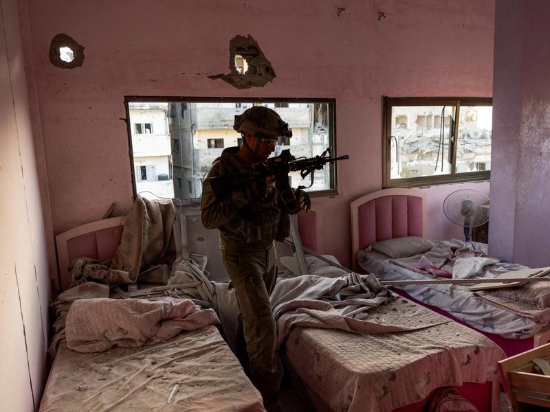An Israeli colonel walks through a damaged bedroom inside a residential building amid the ongoing operation against Palestinian Islamist group Hamas in the northern Gaza Strip, November 8, 2023.