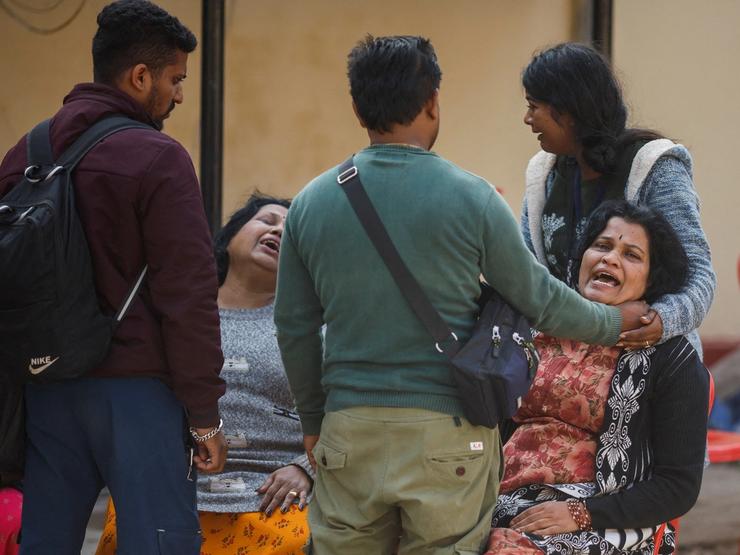 People gather at a hospital mortuary after the stampede
