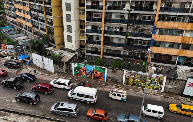 A drone view shows vehicles driving past murals in Lagos.