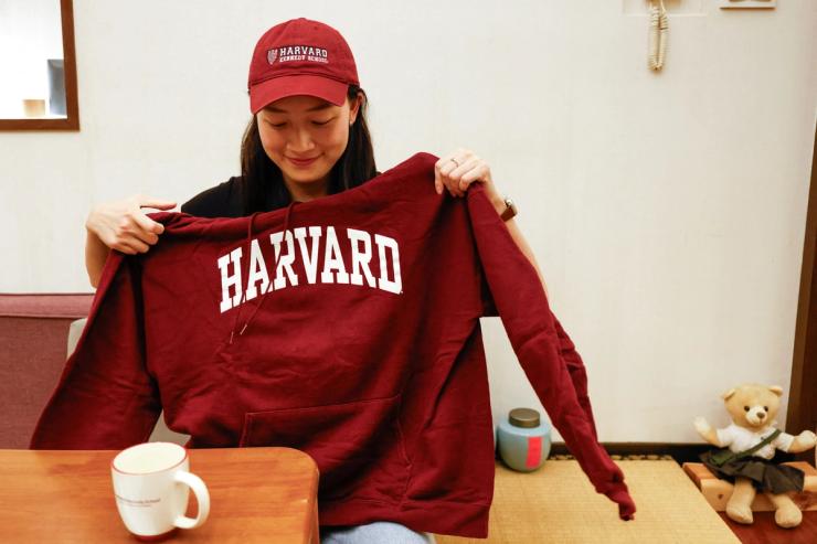 Yu-Hsuan Lin, 27, poses for a photo with a Harvard hat and hoodie in Taipei, Taiwan