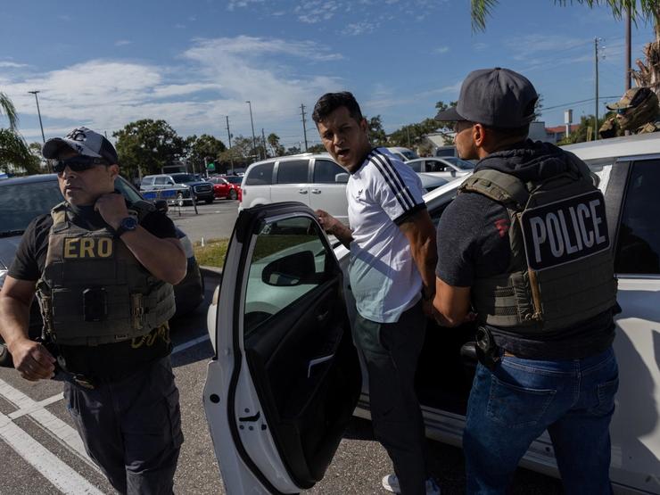Federal agents arrest a man in an immigration enforcement operation.