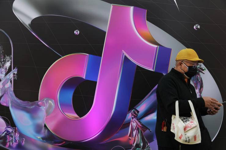 A man stands near a giant sign of Chinese company ByteDance’s app TikTok, known locally as Douyin, during China Fashion Week, in Beijing.
