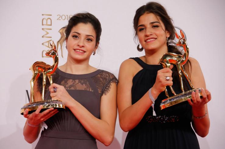 Syrian refugee swimmers Yusra (L) and Sarah Mardini pose with the Silent Heroes award in Berlin, Germany, November 17, 2016.