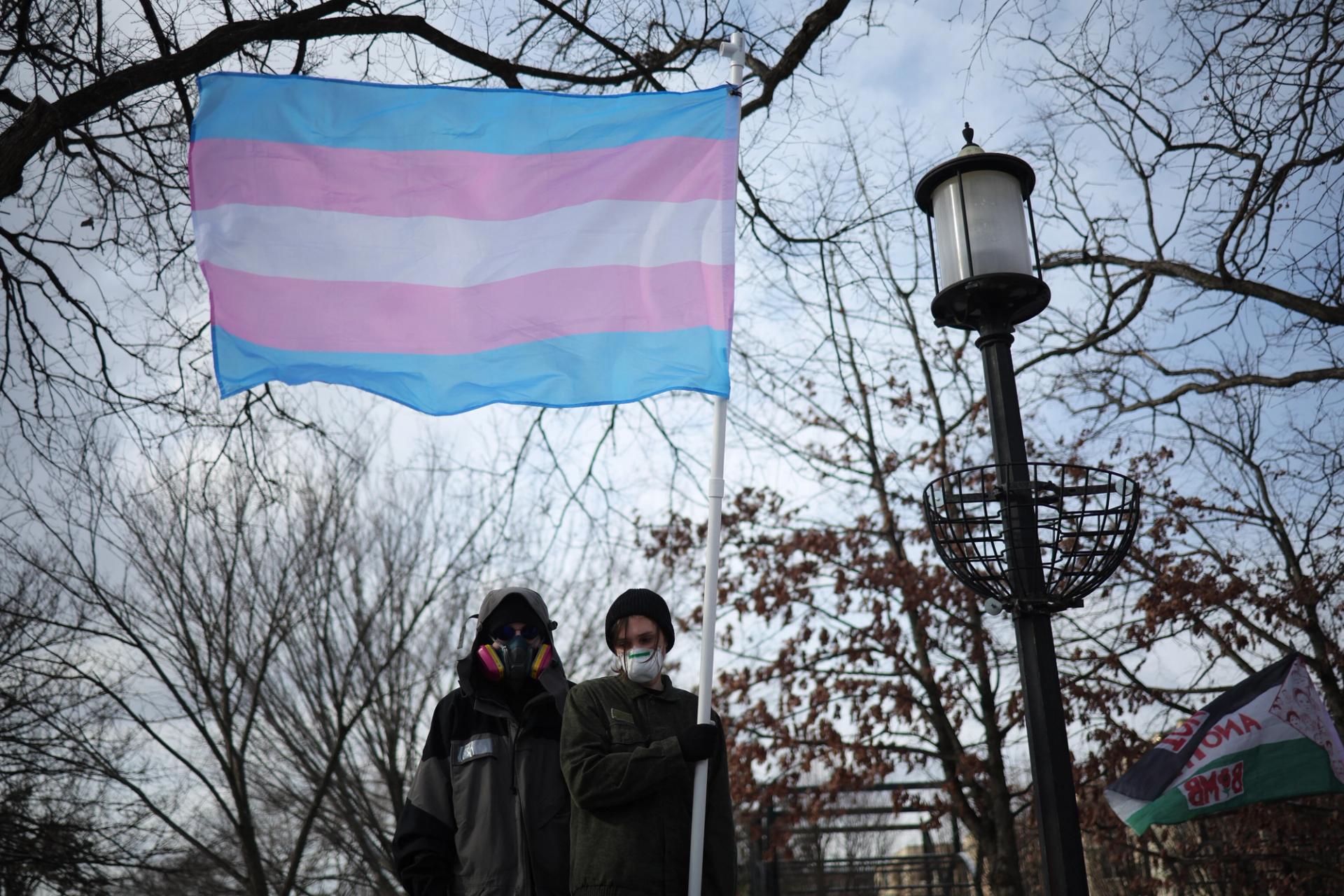 A protester displays a transgender flag at Meridian Hill Park in Washington, DC.