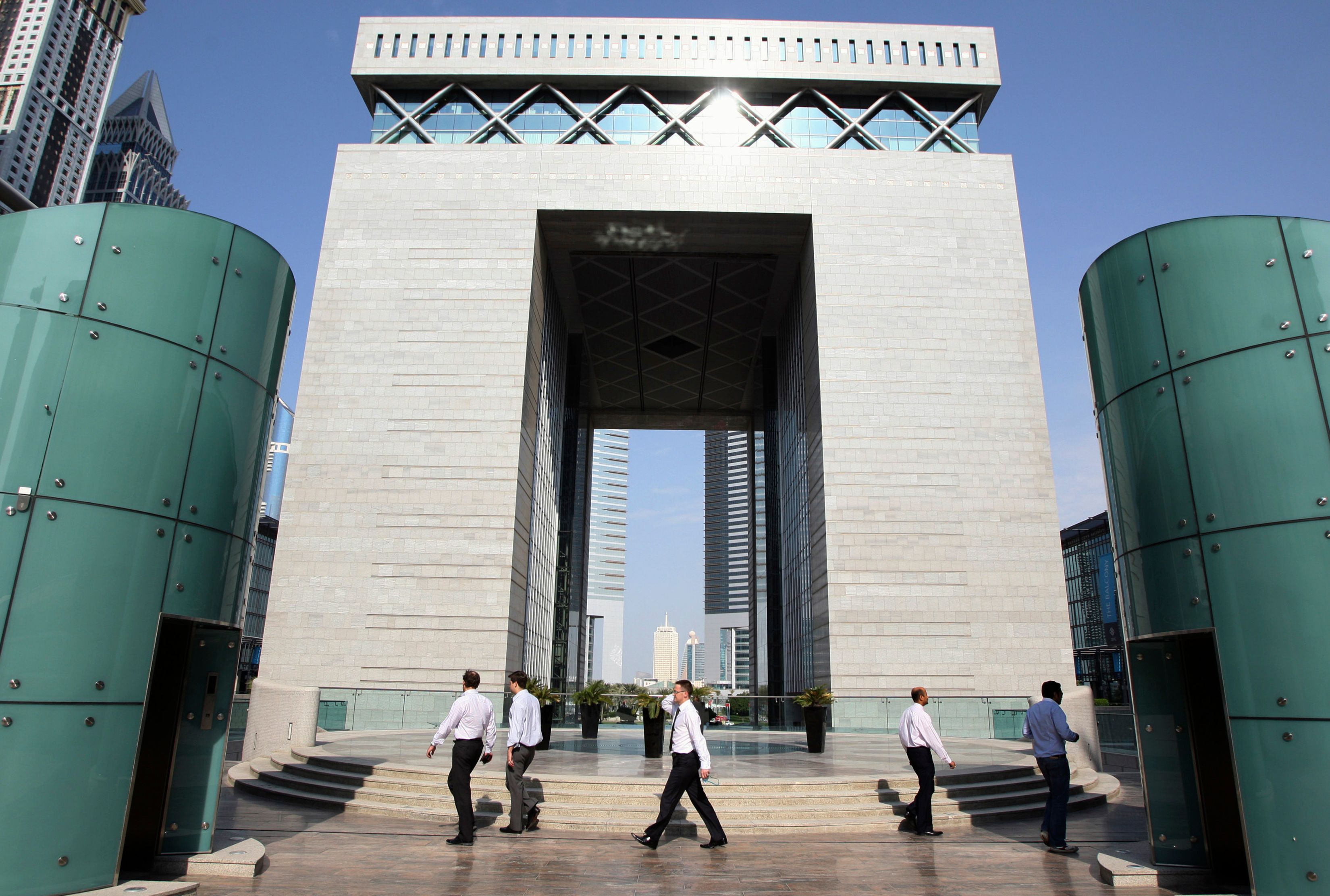 People walk outside the Gate Building at the Dubai International Financial Centre (DIFC) November 28, 2011.