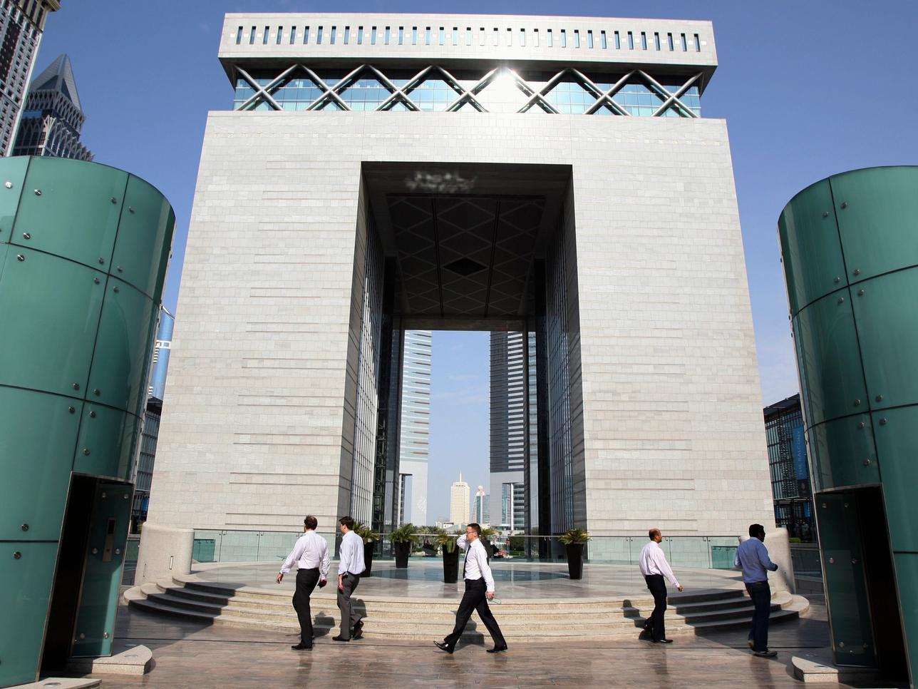 People walk outside the Gate Building at the Dubai International Financial Centre (DIFC) November 28, 2011.